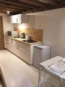 uma cozinha com um lavatório, um fogão e uma mesa em Studio 30m2 centre de Cusset em Cusset