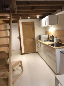 uma cozinha com um fogão e uma porta para um quarto em Studio 30m2 centre de Cusset em Cusset