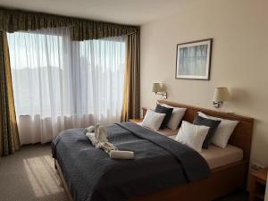 a hotel room with a bed with a towel on it at Hotel Estella Superior in Eger