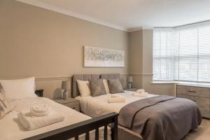 a bedroom with two beds with towels on them at Comfortable 5-Bedroom House in Cheltenham in Cheltenham