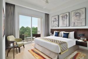 1 dormitorio con 1 cama grande y 1 silla en Citadines Arpora Nagoa Goa en Arpora