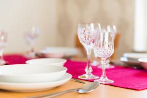 einen Tisch mit zwei Weingläsern auf einer roten Serviette in der Unterkunft Ferienwohnung John in Eisenach