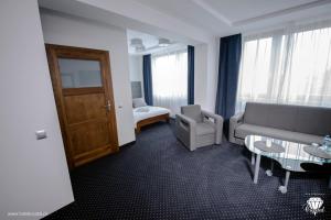 - un salon avec un canapé et une chaise dans l'établissement Hotel Crystal, à Janikowo