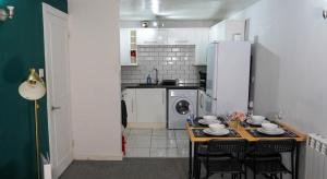 a kitchen with a table with chairs and a refrigerator at Central Canterbury Apartment with Parking in Kent