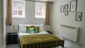 a bedroom with a bed with two pillows on it at Central Canterbury Apartment with Parking in Kent