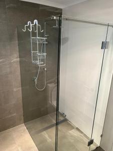 a shower with a glass door in a bathroom at A Perfect Place in Seacliff