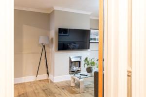 a living room with a fireplace and a flat screen tv at Comfortable 5-Bedroom House in Cheltenham in Cheltenham