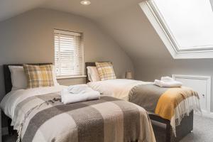 two beds sitting next to each other in a room at Comfortable 5-Bedroom House in Cheltenham in Cheltenham