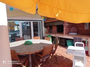 a dining room table with chairs and an umbrella at chez Sylvie et Alain in Lamas