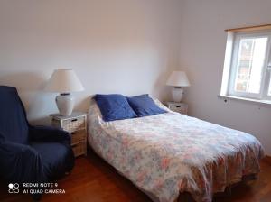a bedroom with a bed and a chair and a window at chez Sylvie et Alain in Lamas +14 photos