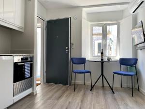 a kitchen with a table and two blue chairs at The Gem of Seixal in Seixal