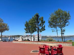 un tavolo e sedie su un patio in mattoni con vista sull'acqua di The Gem of Seixal a Seixal