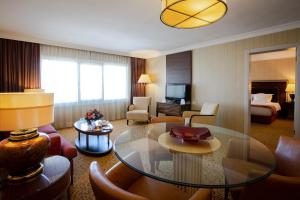 Habitación de hotel con mesa y sala de estar. en Buyukhanli Park Hotel en Ankara