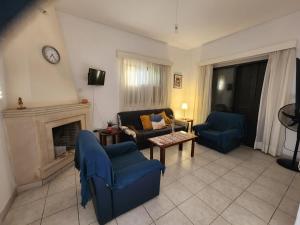 sala de estar con sillas azules y chimenea en Serena Vacation Home, en Pomos