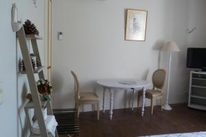 Habitación con mesa, 2 sillas y TV. en Chambre d'Hôtes de L'Abricotier, en Saint-Macaire