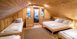um quarto com 2 camas num chalé de madeira em Tündérkert Apartman em Debrecen