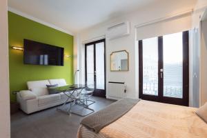 a bedroom with a bed and a green wall at El balcón de la vela in Granada