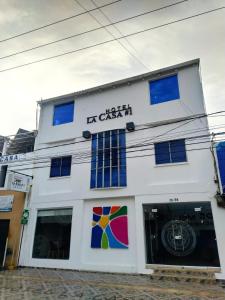 a white building with a sign on it at Hotel La Casa 1 in Montería