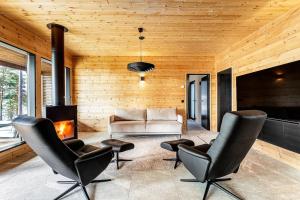a living room with leather chairs and a fireplace at Saunamäki - Luoto in Salo