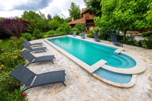una piscina con tumbonas y una piscina en Tündérkert Apartman, en Debrecen