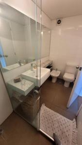 a bathroom with a sink and a toilet and a mirror at Precioso apartamento en moderno edificio in Montevideo