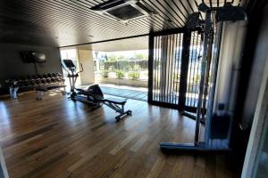 un gimnasio con 2 cintas de correr en un suelo de madera dura en Precioso apartamento en moderno edificio en Montevideo