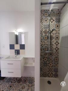 a white bathroom with a shower and a sink at DOUMO in Agde