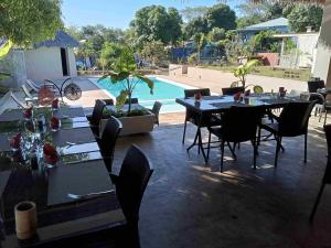 un patio con tavoli e sedie accanto alla piscina di MAISON CARREE ad Andilana
