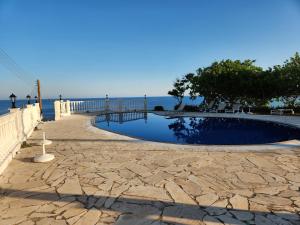 a swimming pool with the ocean in the background at Serena Vacation Home in Pomos