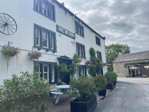 a white building with a bench in front of it at New Inn Hotel in Clapham