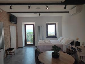a bedroom with a bed and a table and two windows at Note di Rame in Castelfidardo