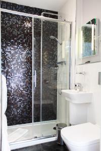 a bathroom with a shower and a toilet and a sink at The Salutation Inn in Topsham