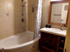 een badkamer met een bad, een wastafel en een douche bij מצפה 1050 in Neve Ativ