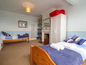 a bedroom with two beds and a fireplace at The Pink House in Felixstowe