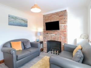 a living room with a couch and a fireplace at Seashell Cottage in Lowestoft
