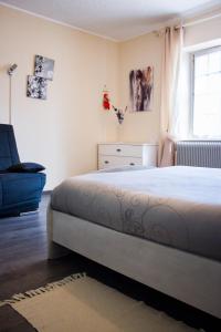 Pouilly-sous-Charlieu奥克斯龙杰酒店的一间卧室，里面有一张床、一把椅子和一扇窗户