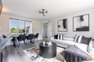 een woonkamer met een bank en een tafel bij Cosy 5 bedroom house - Central By Valore Property Services in Loughton
