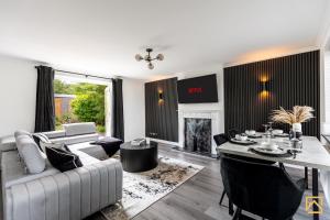 a living room with a couch and a table at Cosy 5 bedroom house - Central By Valore Property Services in Loughton