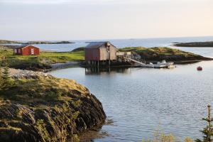 um corpo de água com casas e um barco em Herøy Brygge 