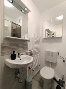a bathroom with a sink and a toilet and mirror at CASEROM Studio in Satu Mare