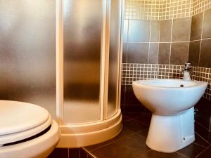 La salle de bains est pourvue d'une douche, de toilettes et d'un lavabo. dans l'établissement Home in Bormio, à Bormio