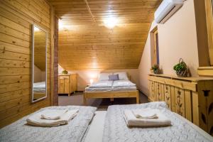 - une chambre avec 2 lits dans une cabane en bois dans l'établissement Tündérkert Apartman, à Debrecen