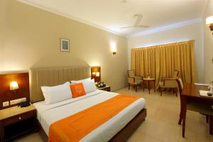 a hotel room with a bed and a desk at Cochin Palace in Cochin