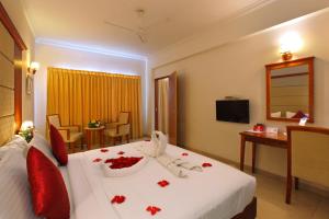 a hotel room with a bed with red flowers on it at Cochin Palace in Cochin