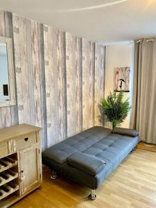 a couch in a room with a wooden wall at Stylish 1 Bedroom Apartment Near Clapham Junction in London