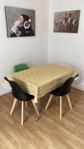 a dining room table with two chairs and a painting at Stylish 1 Bedroom Apartment Near Clapham Junction in London