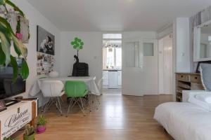 a white living room with a table and chairs at Stylish 1 Bedroom Apartment Near Clapham Junction in London