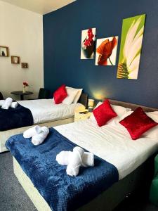 1 dormitorio con 2 camas y almohadas rojas y blancas en A&A Luxury Stay Bettys en Pallion