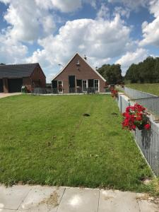 un patio con una valla y una casa en De Dagloner en Nieuwlande