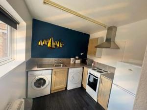 a kitchen with a washing machine and a washer at A&A Luxury Stay Bettys in Pallion